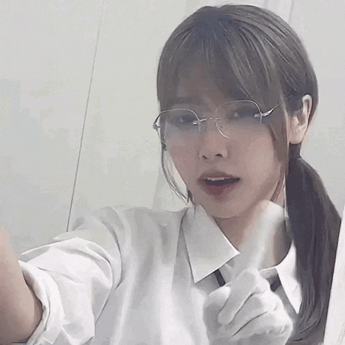the girl is wearing glasses and a white shirt and tie .