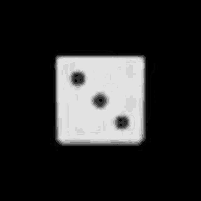 a white dice with holes in it is sitting on a black surface .
