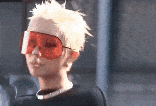 a woman with blonde hair wearing red sunglasses