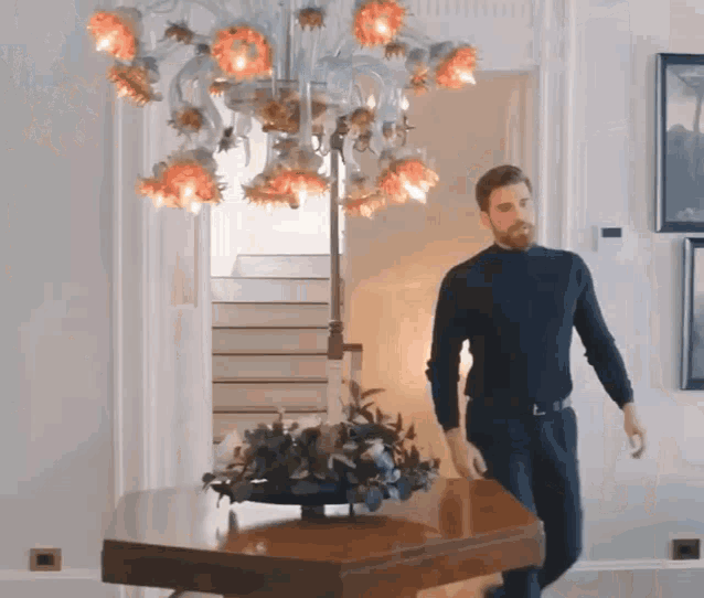 a man standing in front of a chandelier in a room