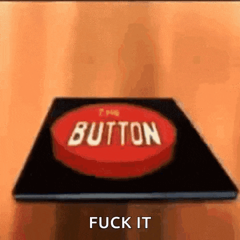 a red button with the words `` button '' written on it is sitting on a wooden table .