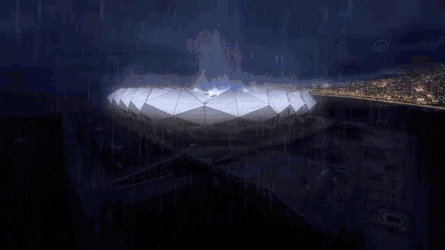 an aerial view of a stadium in the rain with a lightning bolt