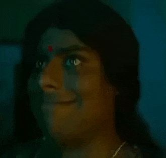a close up of a woman 's face with a bindi on her forehead .