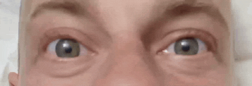 a close up of a person 's eyes with a surprised look on their face .