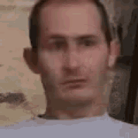 a close up of a man 's face in a white shirt .