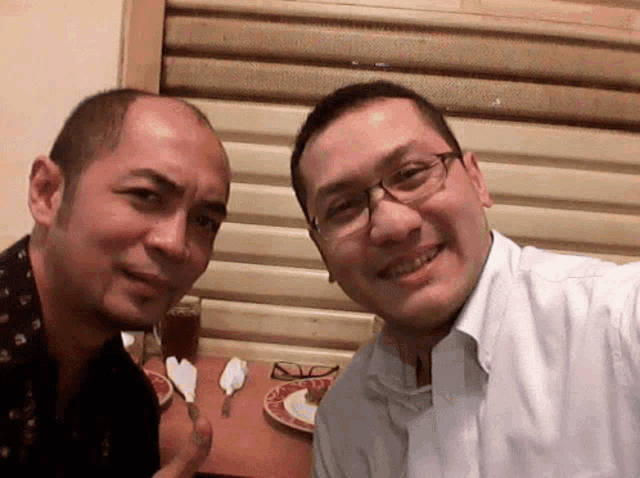 two men posing for a picture with glasses on