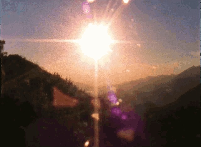 a sunset with the sun shining brightly through the trees