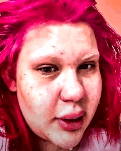 a close up of a woman 's face with red hair .