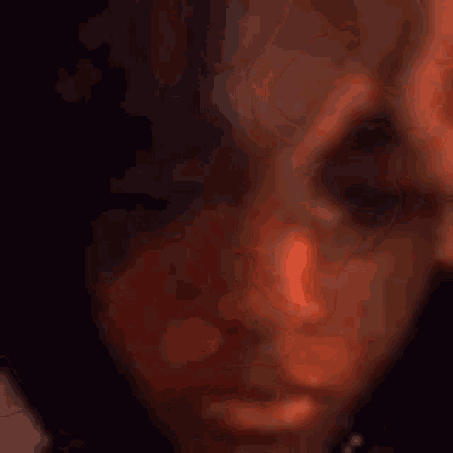 a close up of a person 's face with a hand on it .
