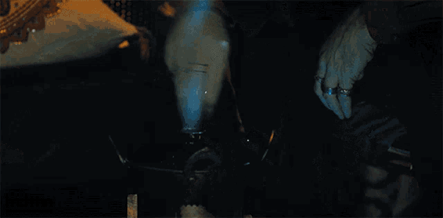 a person smoking a hookah with blue smoke coming out of their mouth