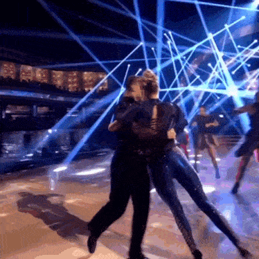 a man and a woman are dancing together on a stage
