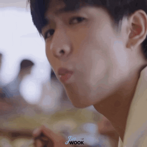 a close up of a person eating with the word wook on the bottom right