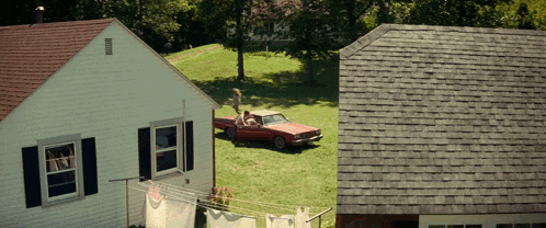 a red car is parked in front of a house