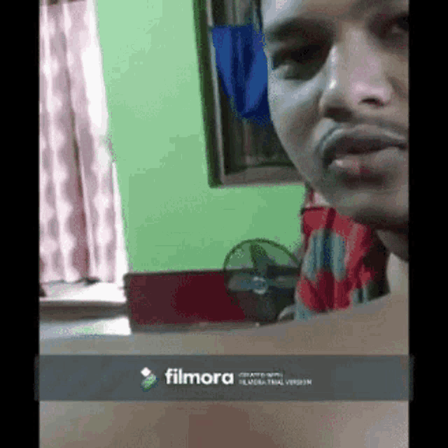 a man is making a funny face in front of a filmora screen