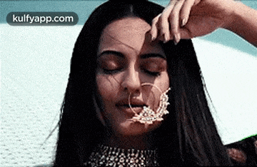a close up of a woman wearing a nose ring and a choker .