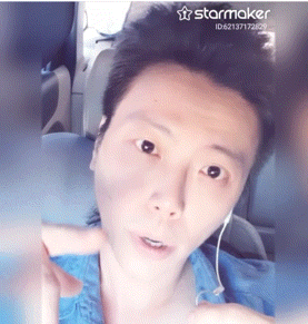 a man is wearing ear buds and a blue shirt and has a starmaker watermark on his face