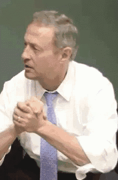 a man in a white shirt and blue tie is talking to someone .