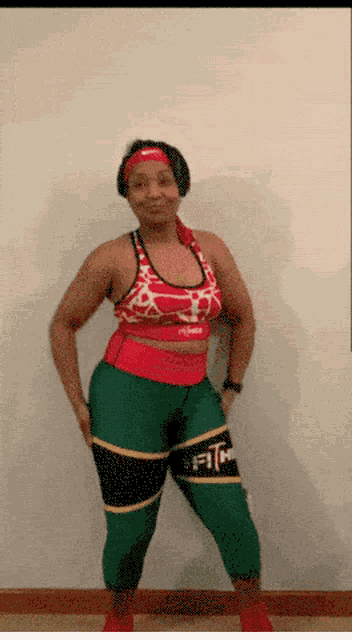 a woman in a red and white top and green pants with the word fit on the thigh