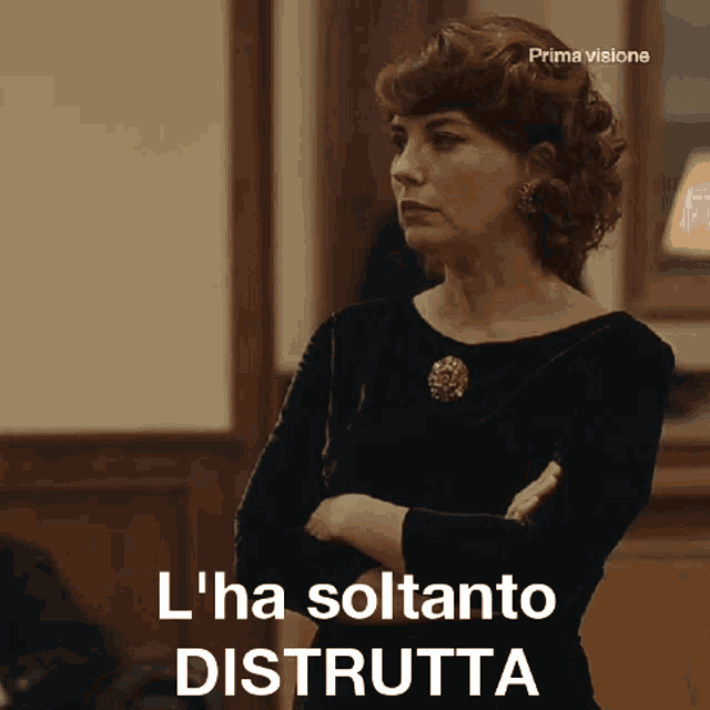 a woman stands with her arms crossed and the words l ' ha soltanto distrutta above her