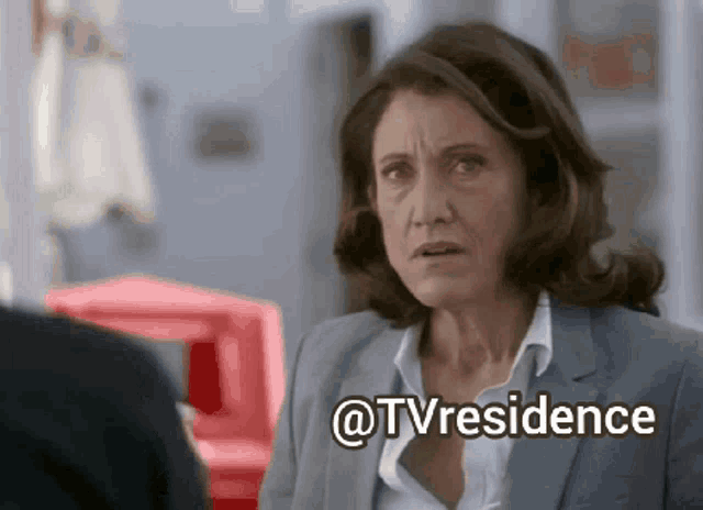 a woman in a suit and white shirt is looking at a man in a suit and says " @tvresidence "