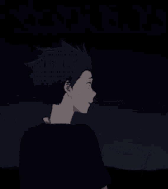 a boy with purple hair is standing in the dark .
