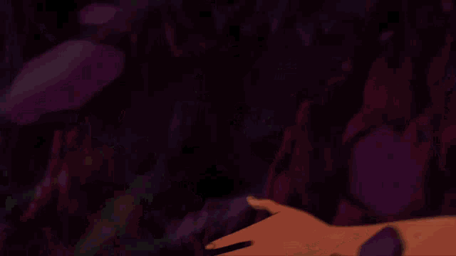 a person 's hand is holding a glowing object in a dark room
