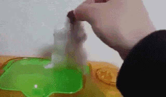 a person is holding a bottle of liquid in their hand .