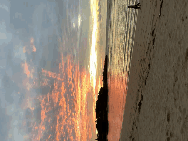 a sunset over a body of water with a silhouette of a person in the water