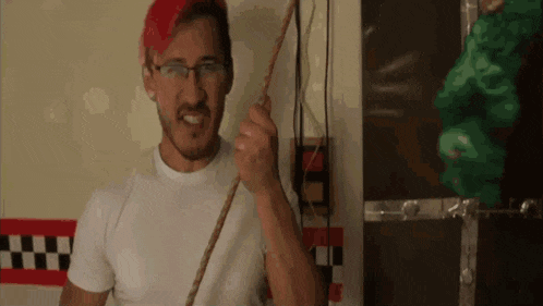 a man wearing glasses and a red hat is holding a rope in his hand