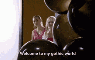 two women are standing in front of a bunch of balloons with the words welcome to my gothic world written on the bottom