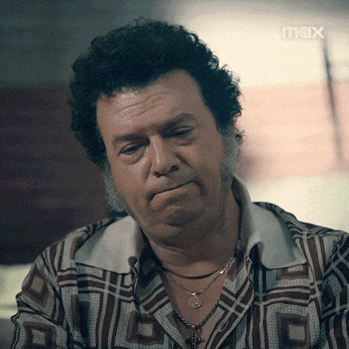 a man with curly hair and a beard is wearing a shirt that says max on it