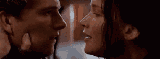 a man and a woman are kissing in front of each other .