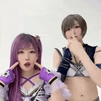two women are standing next to each other and making funny faces . one of the women has purple hair .