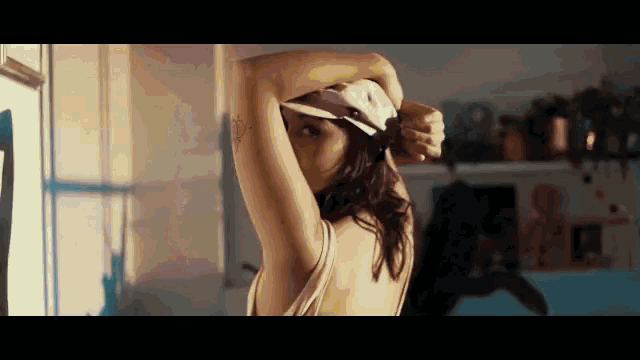 a woman with a tattoo on her arm is wearing a hat