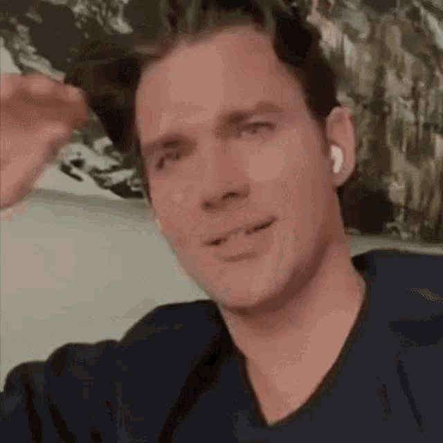 a man wearing ear buds is sitting on a couch .