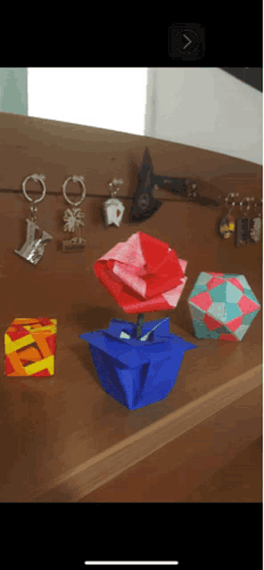 an origami flower is sitting on a table next to other origami objects