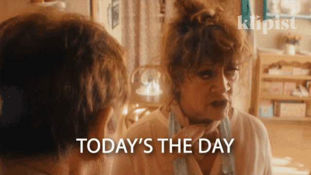 a woman is looking at herself in a mirror and the words today 's the day are below her