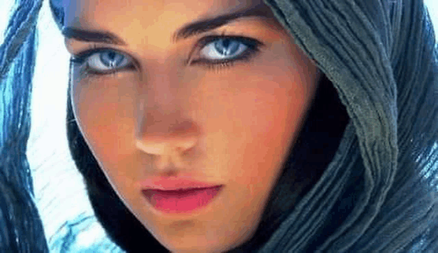 a close up of a woman 's face with blue eyes and a scarf on her head .