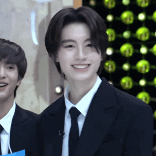 a man in a suit and tie is smiling and looking at the camera