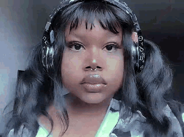 a close up of a woman wearing headphones and earrings .