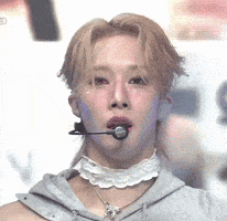 a close up of a person wearing a choker and a microphone in their mouth .