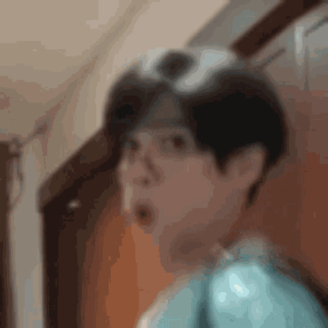 a close up of a person 's face with a surprised look on their face