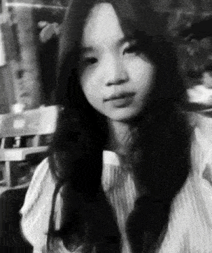 a black and white photo of a girl with long hair .