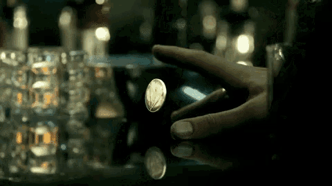 a person 's hand is reaching for a coin that says ' united states of america ' on it