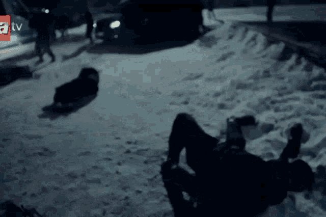 a person laying on their back in the snow with a tv logo behind them