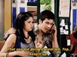 a man and a woman are talking on a cell phone and the woman is saying that you are doing a great job .