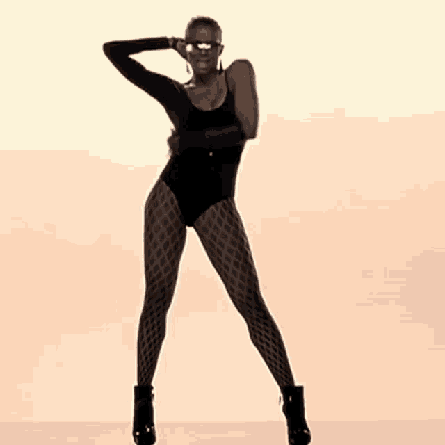 a woman in a black leotard and black tights is dancing