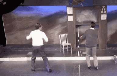 two men are dancing in front of a sign that says a on it