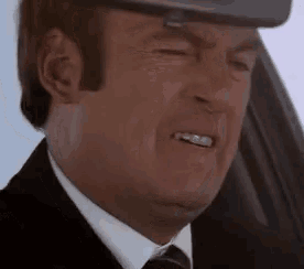a close up of a man wearing a suit and tie making a funny face .