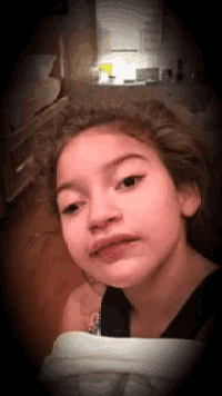 a young girl making a funny face in a kitchen